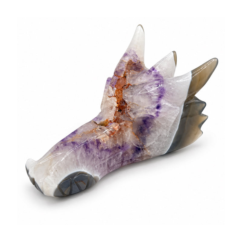 White and lavender stone dragon skull with three horns, orange mineral veins and a long snout, front three-quarter view on white.