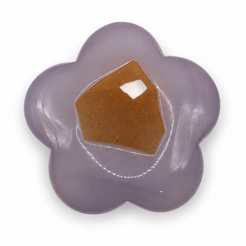 Muted lavender five-petal stone flower with a large angular amber-colored patch and glossy reflections.