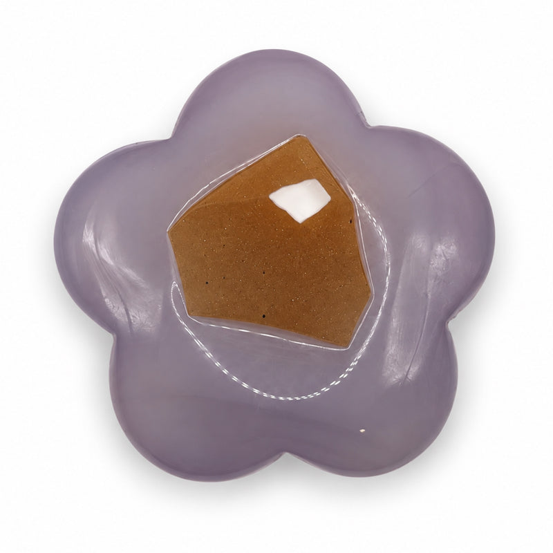 Muted lavender five-petal stone flower with a large angular amber-colored patch and glossy reflections.