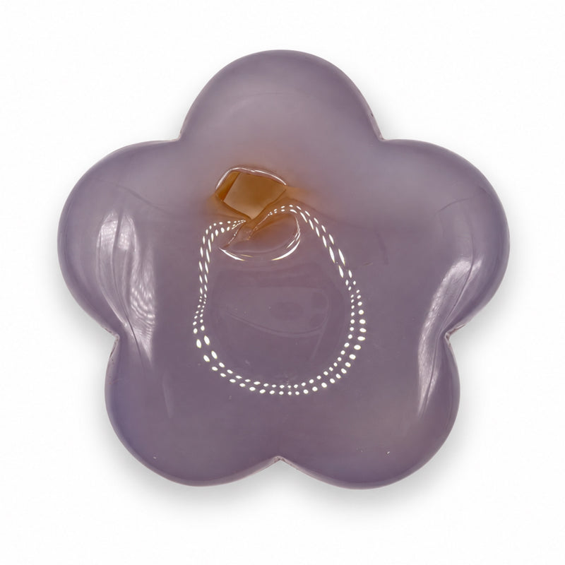 Opposite face of a muted lavender stone flower with a small amber-colored area near the upper center and glossy reflections.